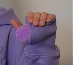 person holding stress balls inside the hoodie