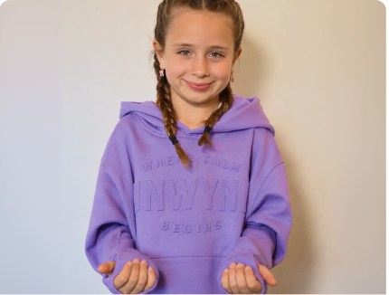 close-up shot of a person wearing a hoodie while holding a stress spheres